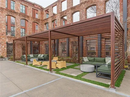 a view of a patio with a table and chairs and wooden fence