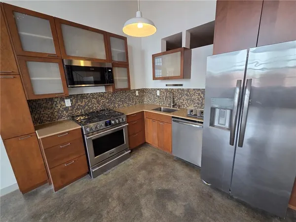 a kitchen with stainless steel appliances granite countertop a refrigerator and a stove top oven