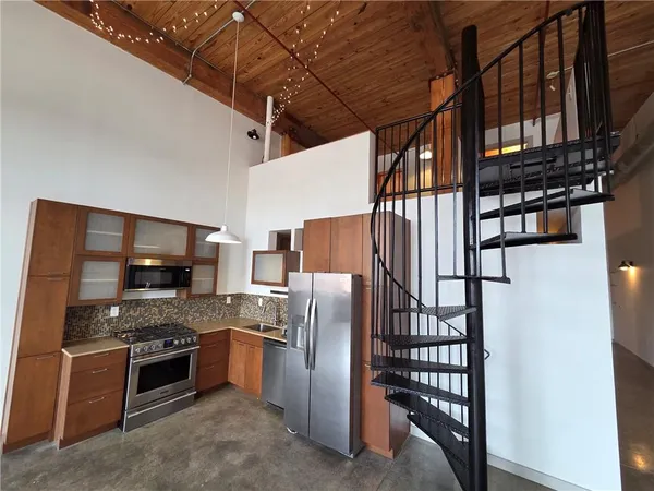 a kitchen with stainless steel appliances granite countertop a refrigerator and a stove top oven