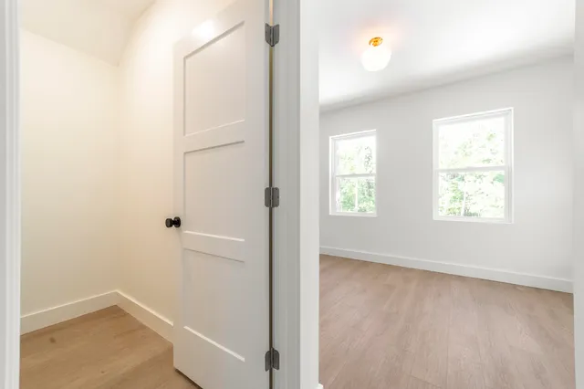 an empty room with windows and closet