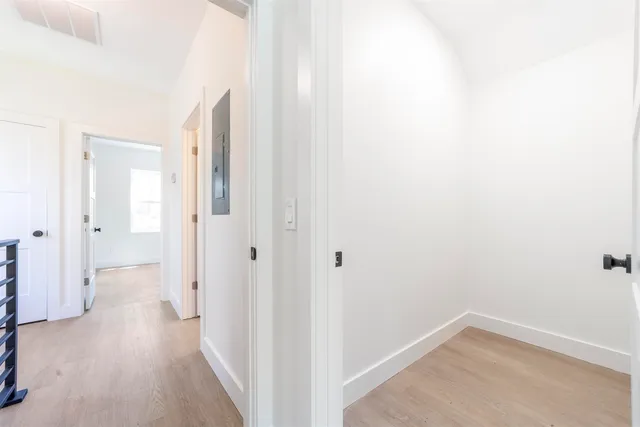 a view of a hallway with wooden floor