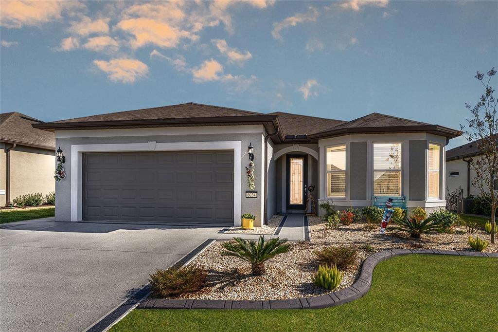 6034 Southwest 86th Circle Ocala, FL 34481 - Photo 1 of 59 a front view of a house with garden