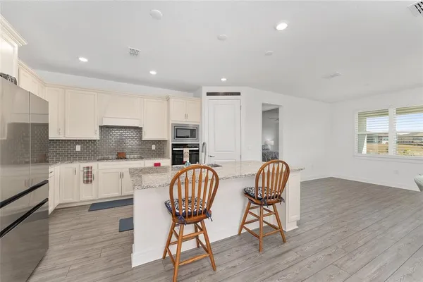 a kitchen with stainless steel appliances granite countertop a stove a sink and a refrigerator