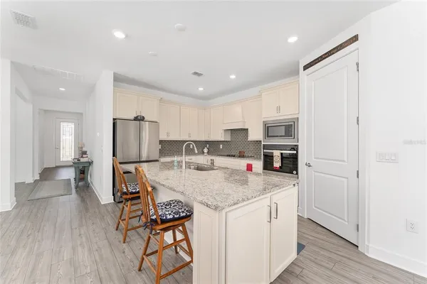 a kitchen with stainless steel appliances granite countertop white cabinets sink and dishwasher