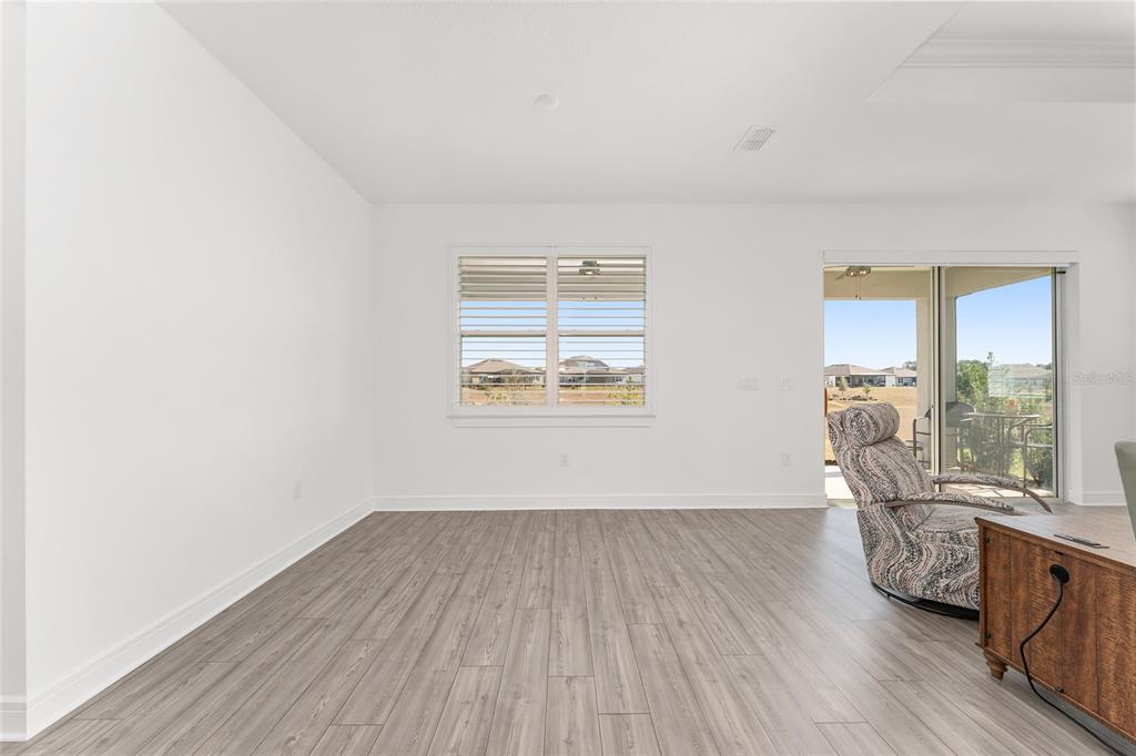 6034 Southwest 86th Circle Ocala, FL 34481 - Photo 19 of 59 an empty room with wooden floor and windows