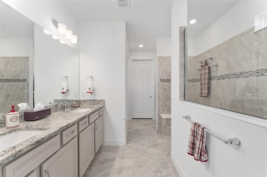 6034 Southwest 86th Circle Ocala, FL 34481 - Photo 22 of 59 a bathroom with a granite countertop sink a large mirror and shower