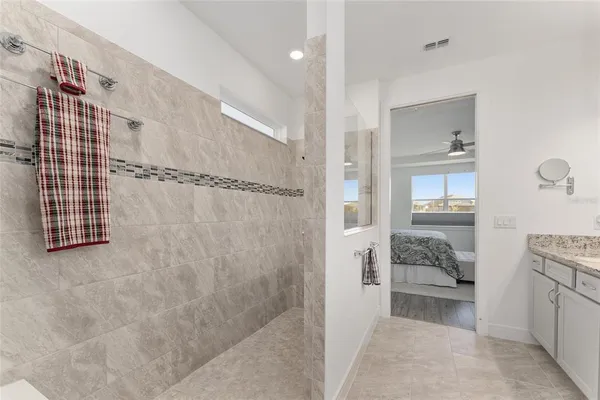 a bedroom with a bed and a dresser with wooden floor