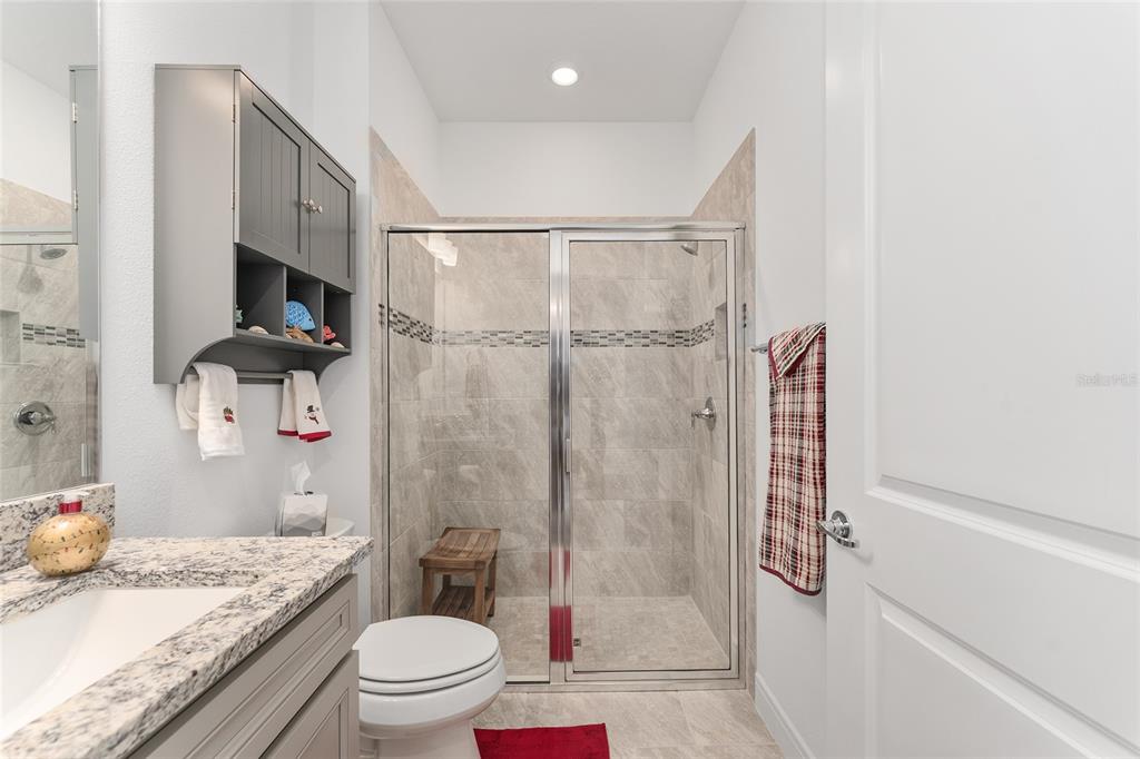 6034 Southwest 86th Circle Ocala, FL 34481 - Photo 29 of 59 a bathroom with a granite countertop sink a toilet and shower