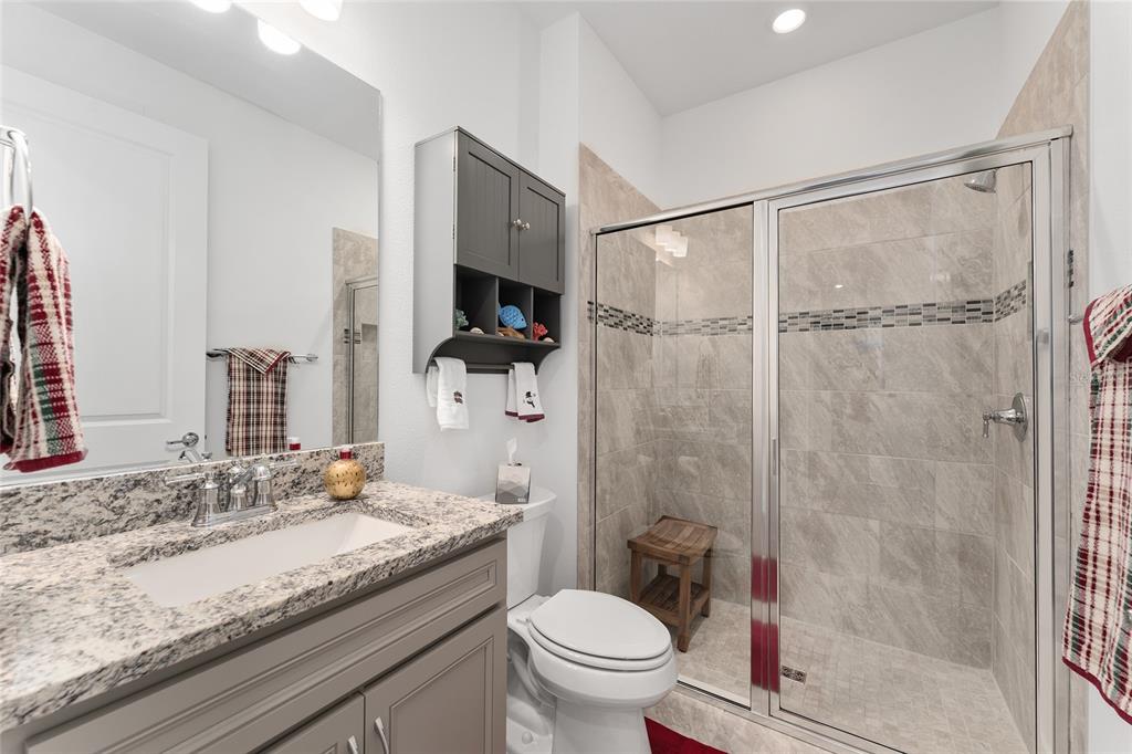 6034 Southwest 86th Circle Ocala, FL 34481 - Photo 30 of 59 a bathroom with a granite countertop sink toilet and shower
