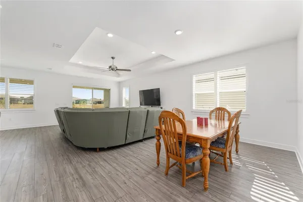 a large living room with furniture and kitchen view