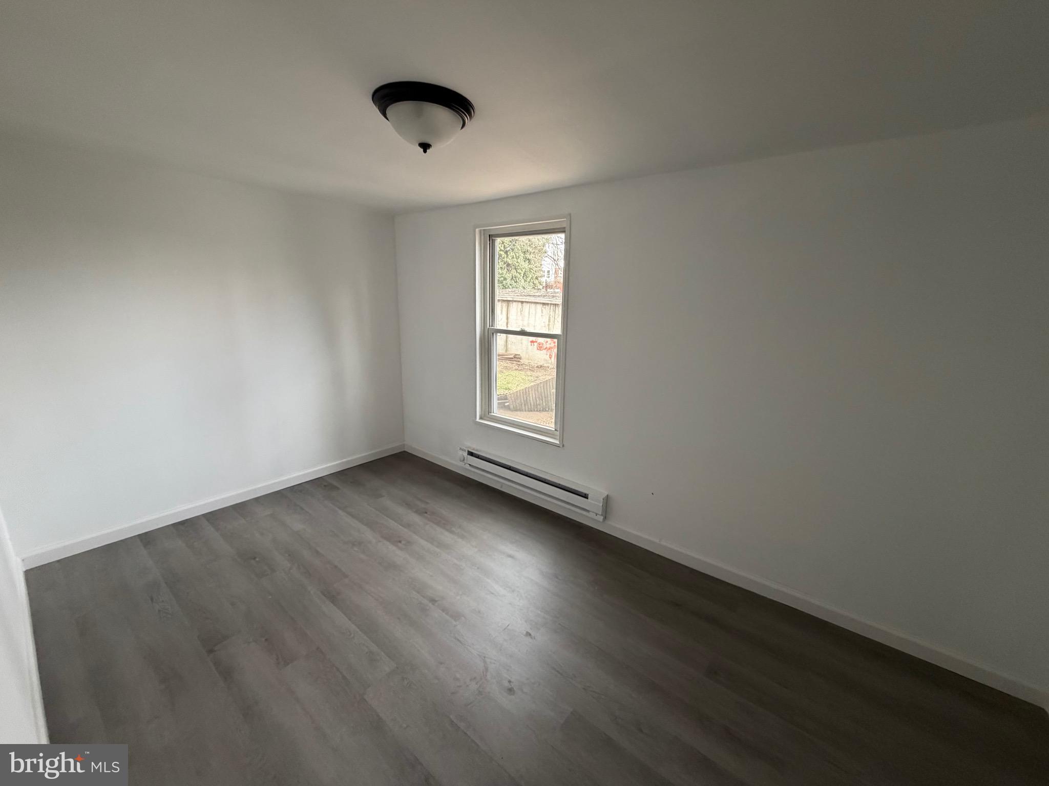 4148 Orchard Street Philadelphia, PA 19124 - Photo 21 of 25 an empty room with wooden floor and windows