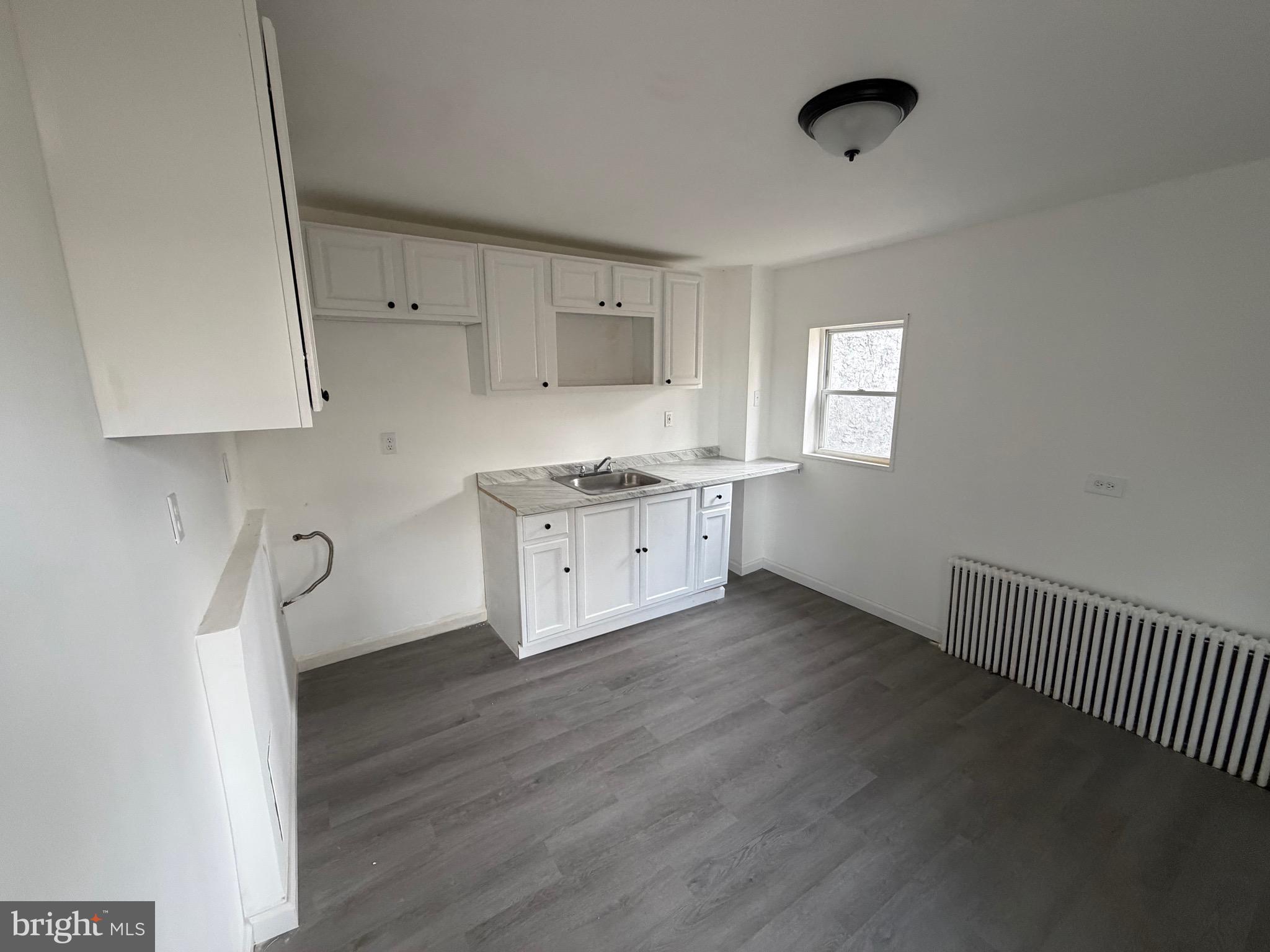 4148 Orchard Street Philadelphia, PA 19124 - Photo 8 of 25 a kitchen with a sink cabinets and wooden floor