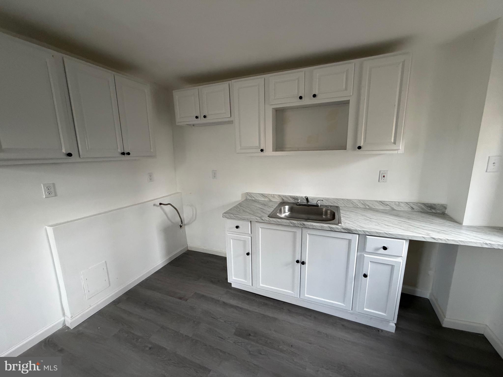4148 Orchard Street Philadelphia, PA 19124 - Photo 10 of 25 a kitchen with granite countertop a sink a stove and cabinets