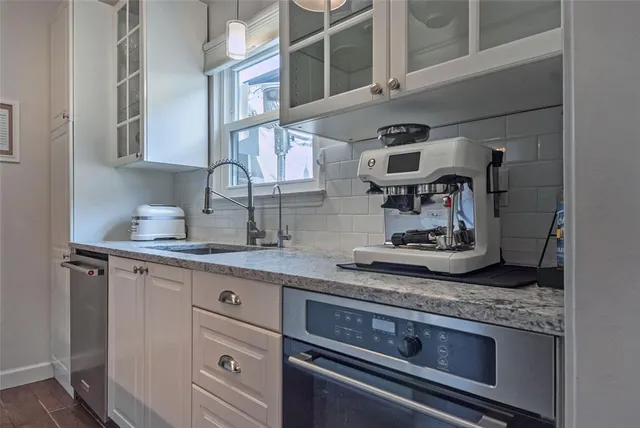 a kitchen with stainless steel appliances granite countertop a sink and cabinets