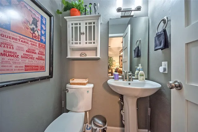 a bathroom with a toilet sink and mirror