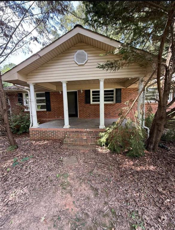 a view of a house with a yard and potted plants