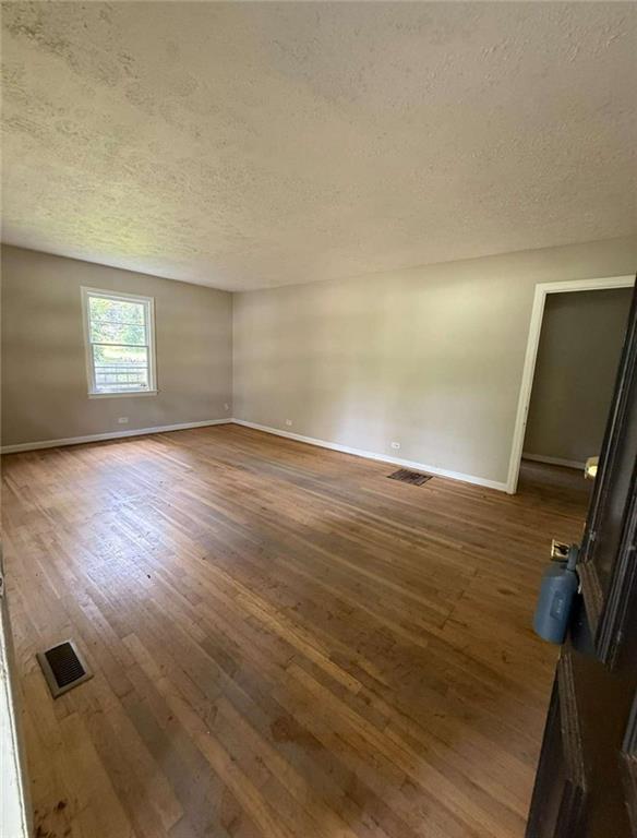 7205 Lakeview Drive Southwest Covington, GA 30014 - Photo 6 of 18 an empty room with wooden floor and windows