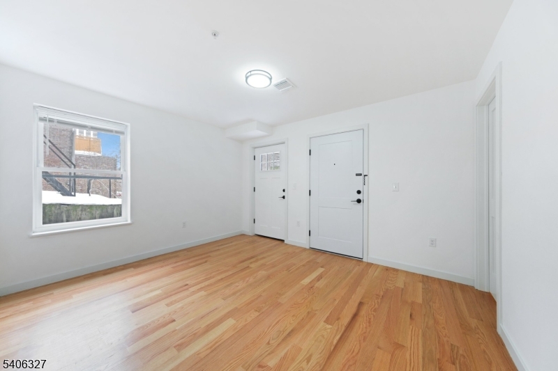 52 James Street, Unit 2 Newark, NJ 07102 - Photo 15 of 27 a view of an empty room with wooden floor and a window