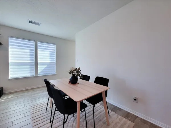 a view of a dining room with a table and chairs