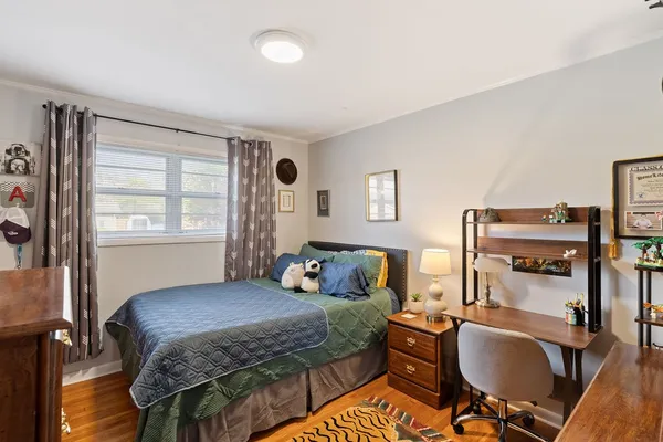 a bedroom with a bed and wooden floor