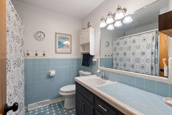 a bathroom with a granite countertop sink a toilet and a mirror