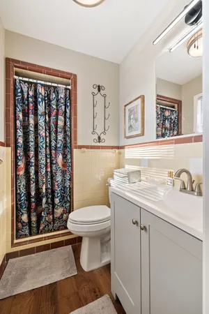 a bathroom with a granite countertop toilet sink and mirror