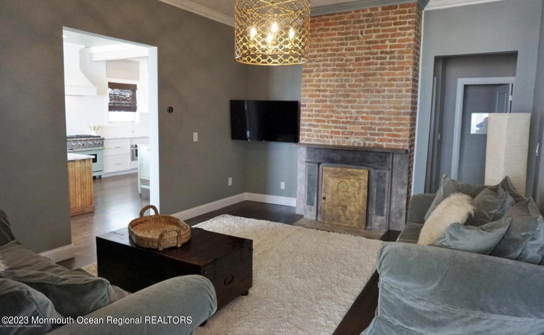 469 Ocean Avenue North, Unit WINTER Long Branch, NJ 07740 - Photo 16 of 47 a living room with furniture and a chandelier
