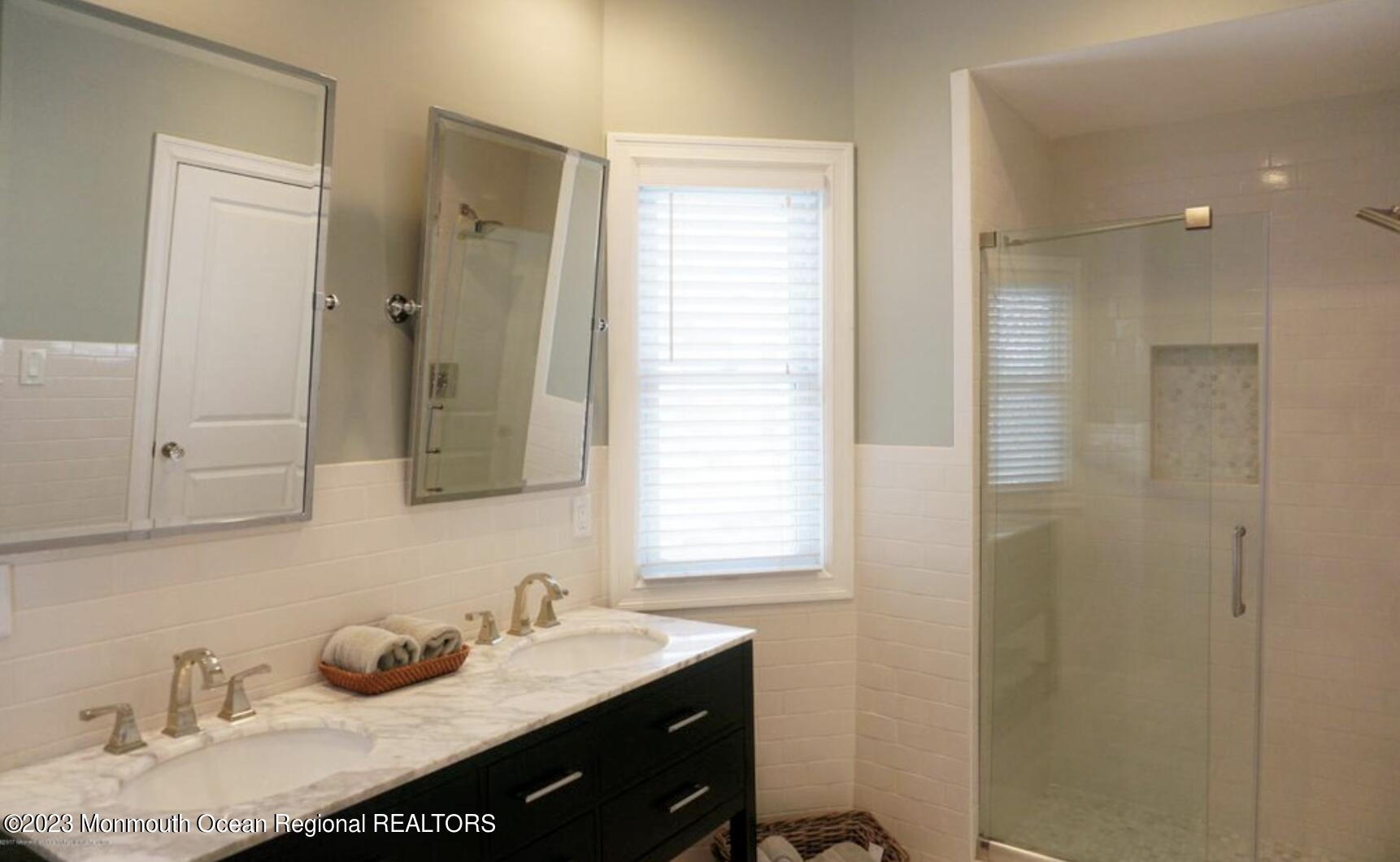 469 Ocean Avenue North, Unit WINTER Long Branch, NJ 07740 - Photo 25 of 47 a bathroom with a granite countertop sink a mirror and shower