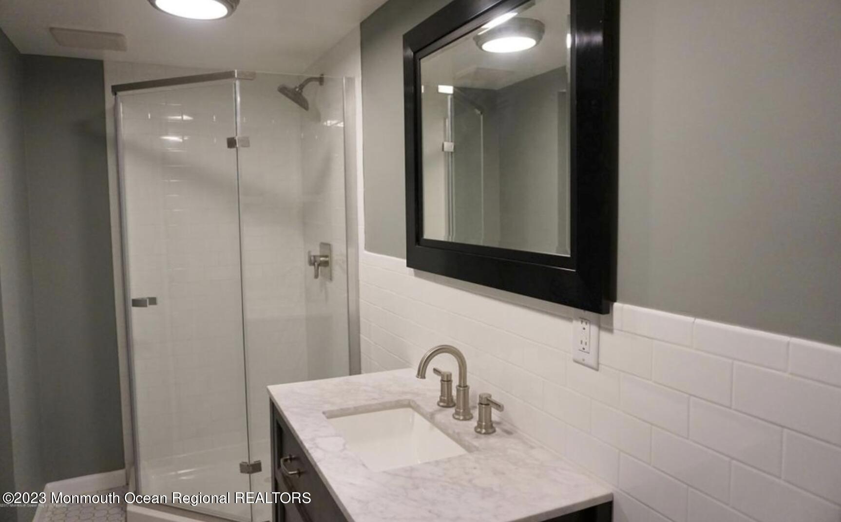469 Ocean Avenue North, Unit WINTER Long Branch, NJ 07740 - Photo 39 of 47 a bathroom with a sink and a mirror
