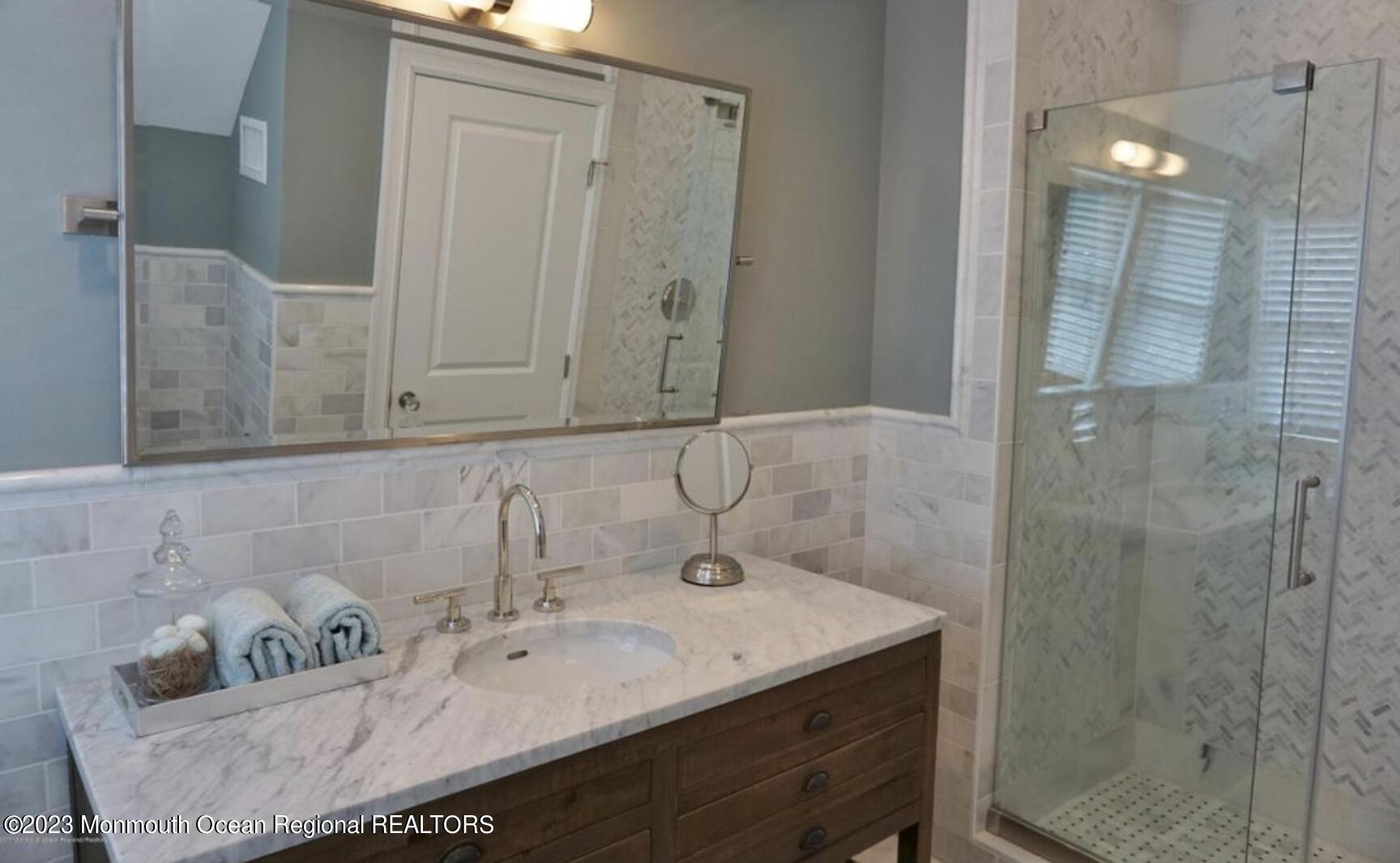 469 Ocean Avenue North, Unit WINTER Long Branch, NJ 07740 - Photo 45 of 47 a bathroom with a sink and mirror