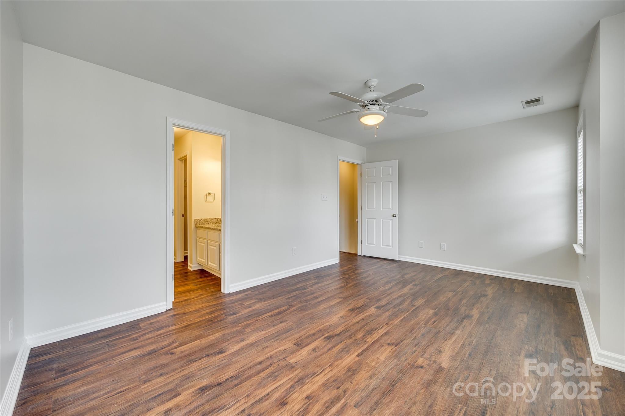 2035 Lennox Square Road Charlotte, NC 28210 - Photo 16 of 29 an empty room with wooden floor and a ceiling fan