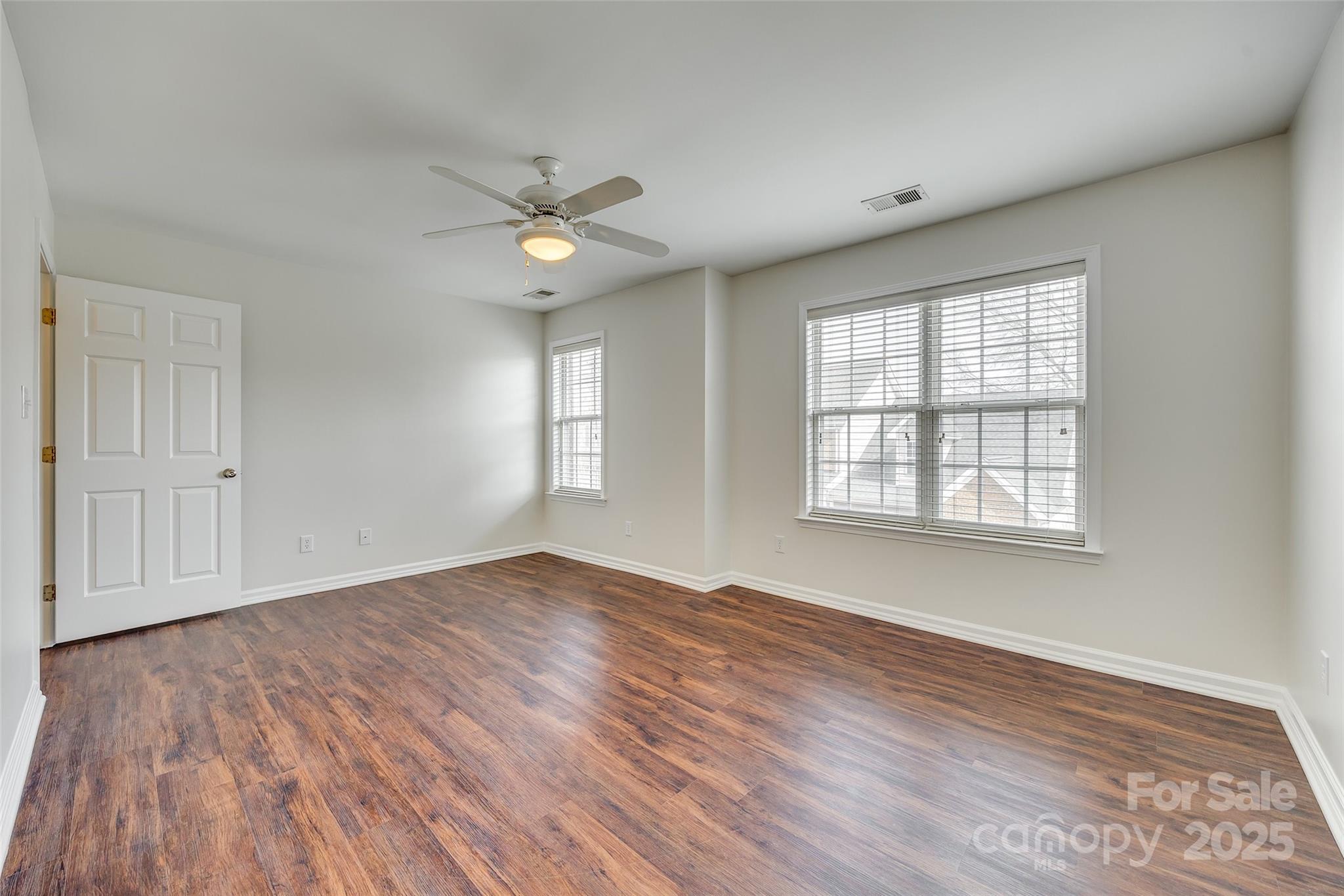 2035 Lennox Square Road Charlotte, NC 28210 - Photo 17 of 29 an empty room with wooden floor ceiling fan and windows