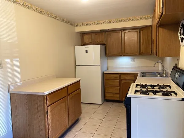 a kitchen with a refrigerator and a stove top oven