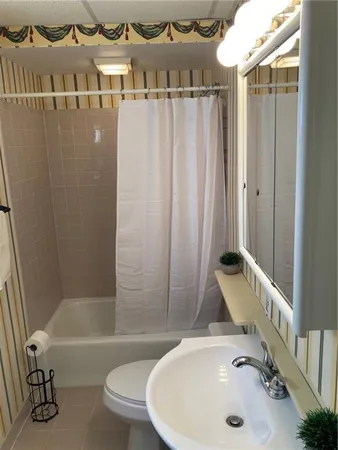 a bathroom with a sink a toilet and bathtub
