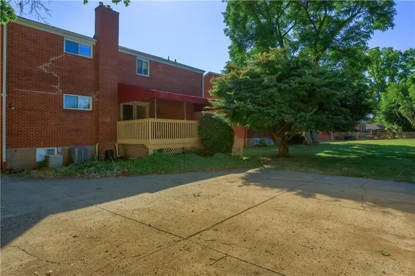 a red brick house with trees in front of it