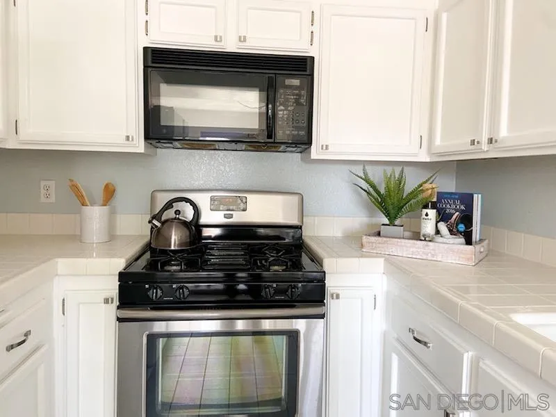 13921 Midland Road Poway, CA 92064 - Photo 5 of 25 a kitchen with stainless steel appliances granite countertop white cabinets and a stove