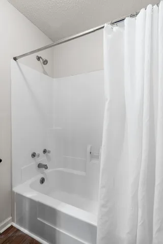 a bathroom with a shower and a bath tub