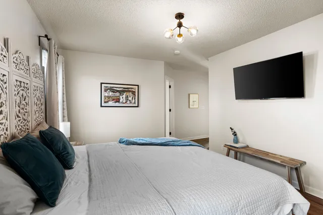 a bedroom with a large bed and a flat screen tv