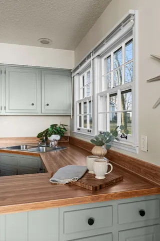 a kitchen with stainless steel appliances granite countertop white cabinets and window