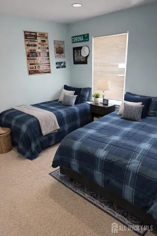 a bedroom with two bed and a night stand