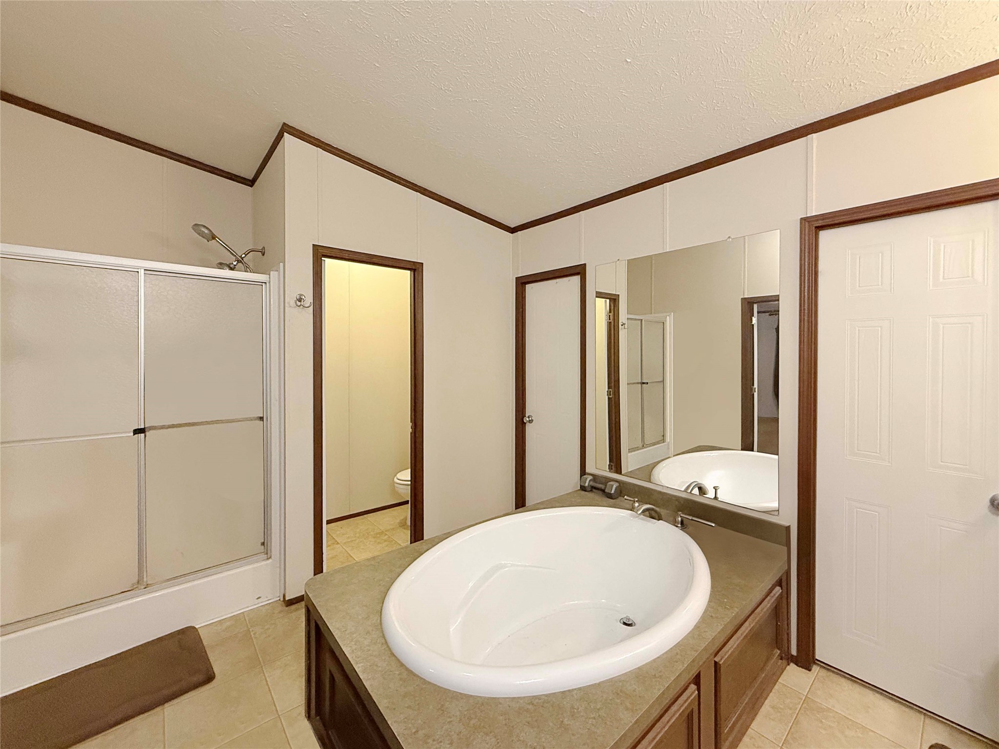 845 Caldwell Street Lexington, TX 78947 - Photo 10 of 39 Full bathroom featuring a soaking tub, a walk in shower, double vanity sink, tile patterned flooring, and lofted ceiling