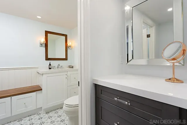 a bathroom with a sink a toilet and a mirror