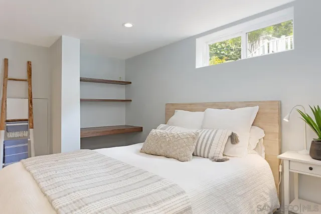 a bedroom with a bed and a painting on the wall