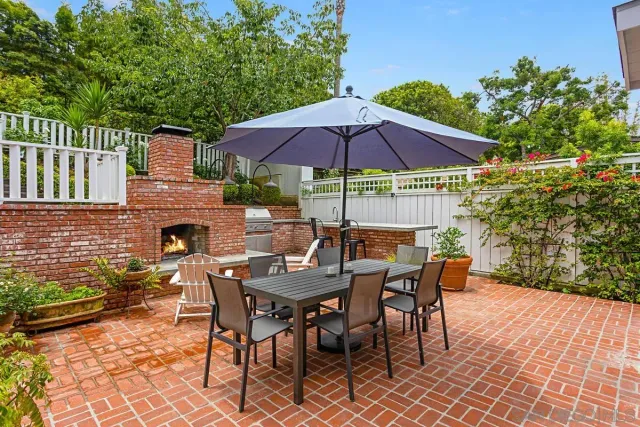 a patio with a table and chairs under an umbrella