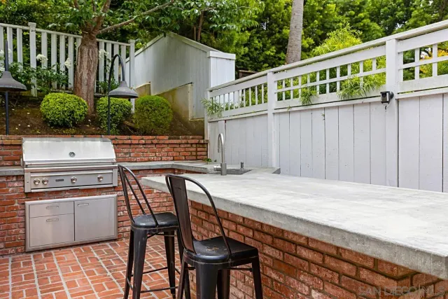 a terrace of a house with wooden floor outdoor seating and yard in the back