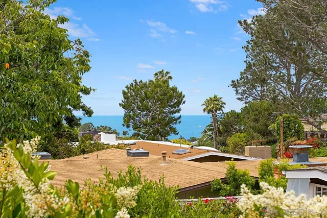 a view of the house with yard and basketball court