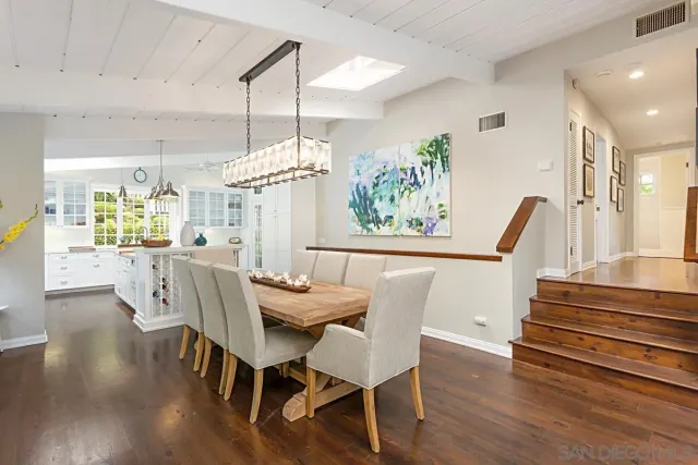 a view of a dining room with furniture a chandelier and wooden floor
