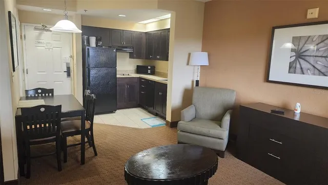 a living room with stainless steel appliances kitchen island granite countertop furniture and a refrigerator