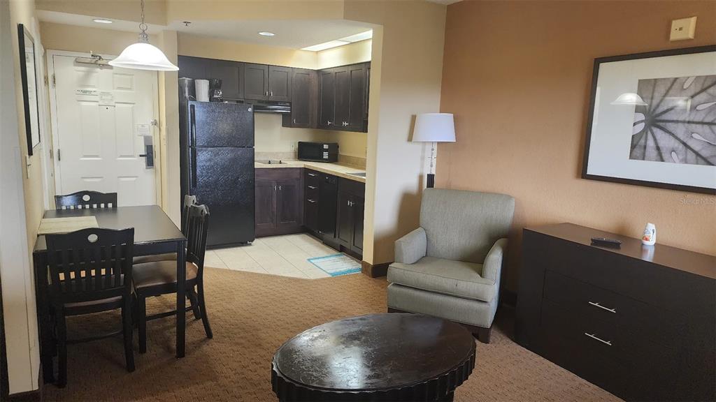 7601 Canada Avenue, Unit 618 Orlando, FL 32819 - Photo 4 of 19 a living room with stainless steel appliances kitchen island granite countertop furniture and a refrigerator
