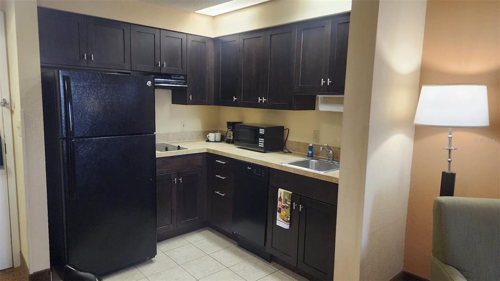 7601 Canada Avenue, Unit 618 Orlando, FL 32819 - Photo 5 of 19 a kitchen with a refrigerator and cabinets